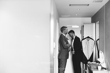 Groom looking at himself in the mirror.