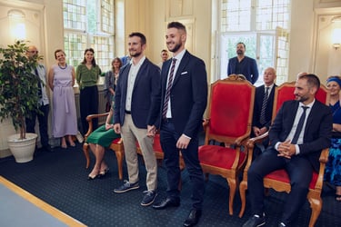 Two grooms standing up during a civil wedding ceremony.