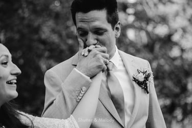 Groom kissing bride's hand.