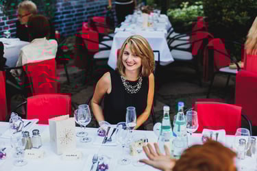 Hochzeitsgast sitzt am Tisch und lächelt.