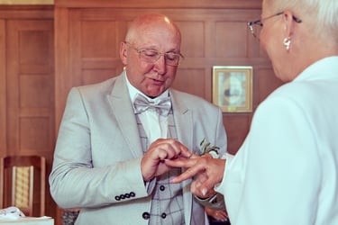 Husband placing a ring on his wife's finger.