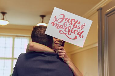 Guest hugging groom with a Just married sign.