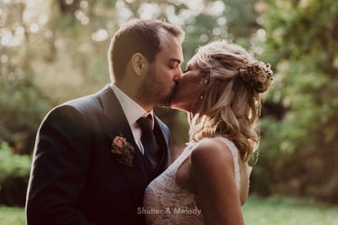 Bride and groom sharing a kiss in a forest.