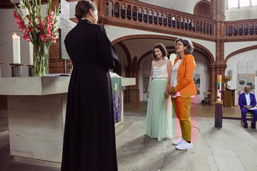 Lesbian couple standing by the altar.
