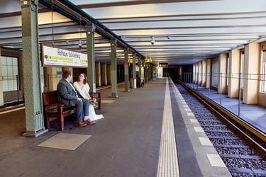 Married couple sitting on the bench at an underground platform.