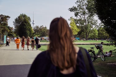 Wedding guests walking in Mauerpark with TV tower in the distance.
