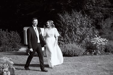 Young married couple walking in a garden.
