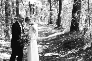 Bride and groom standing on a path leading in the countryside.