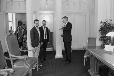 Civil registrar showing seats to a young gay couple.