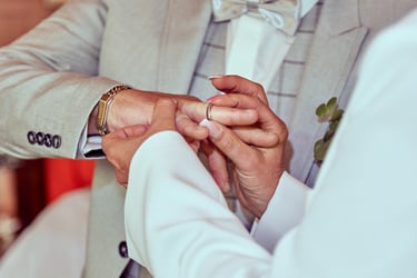 Die Ehefrau steckt ihrem Mann einen Ring an den Finger.