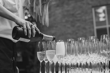 Waitress pouring champagne into glasses.