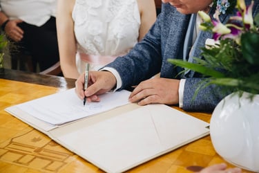 Groom signing marriage documents.