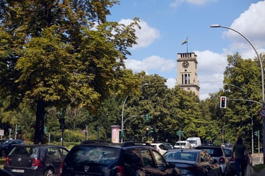 Turm des Standesamtes Tempelhof-Schöneberg über einer Baumreihe.
