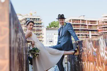 Bride and groom photographed between walls covered in graffiti.