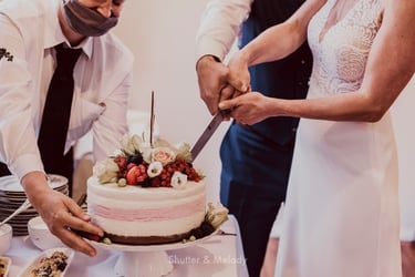 Bride and groom cutting a cake together.