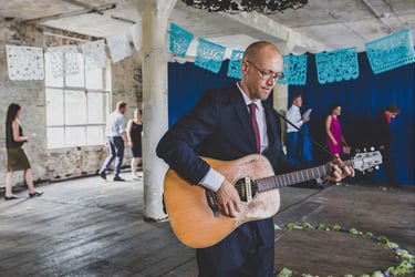 Man playing guitar during a wedding ceremony.