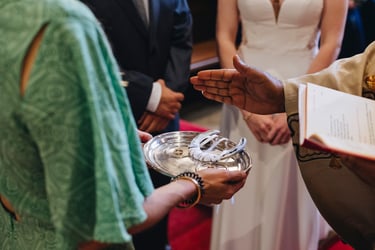 Catholic priest blessing wedding rings.