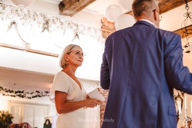 Wife listening to her husband's speech during a reception.