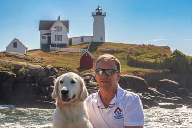 “Golden retriever sitting near Nubble Lighthouse in York, Maine, symbolizing trust and peace of mind