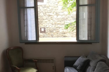 Living room with open windows and church view in Quillan holiday rental