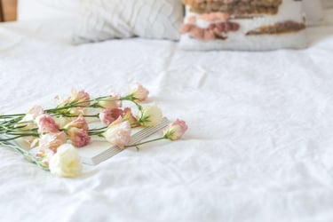 a cake with flowers on a bed in a bedroom