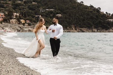 a man and woman walking along a beach in Bonassola