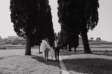 a bride and groom walking down a path in a field