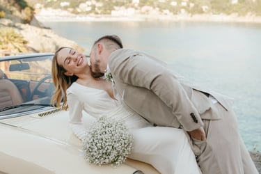 a man and woman kissing in front of a car in Bonassola wedding