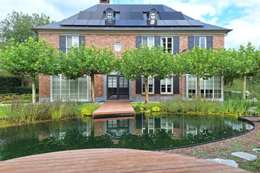Tuin met grote zwemvijver en natuurlijke beplanting