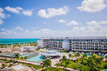 a large hotel with a pool and a view of the ocean