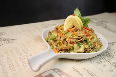 a bowl of "pancit guisado" with lemon toppings