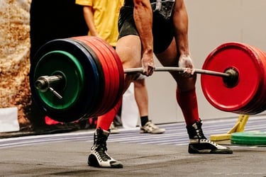 A competitive powerlifter performs a heavy deadlift with a loaded barbell at a weightlifting competition.