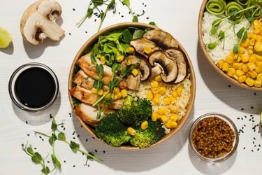 Healthy chicken buddha bowl with grilled mushrooms, broccoli, corn, and quinoa.