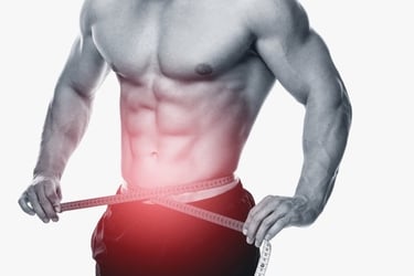 Muscular man measuring his waist with a tape for weight loss and fitness tracking.
