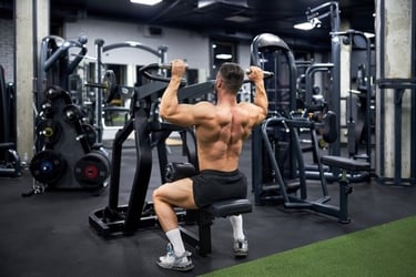 Muscular man performing back exercises on a lat pulldown machine in a modern gym.