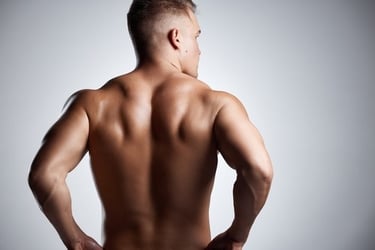 Muscular man displaying defined back muscles and triceps in a fitness bodybuilding pose.
