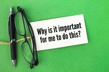 A black pen and eyeglasses resting on a card that reads 'Why is it important for me to do this?