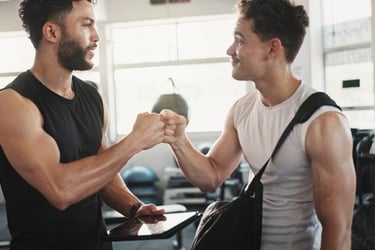A personal trainer and his client fist bumping in a gym after a successful workout session.