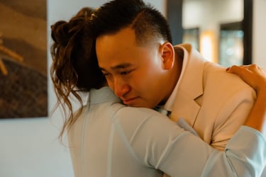 a man in a suit and tie is hugging a woman