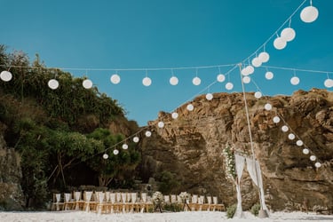a wedding ceremony with white chairs and white chairs