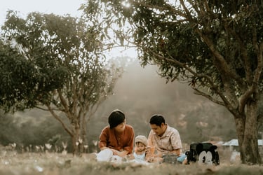 a woman and her husband are sitting on the grass