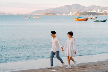 a man and woman walking on the beach