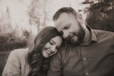 Father and teenage daughter share a tender moment as she rests her head on his shoulder during a Dul
