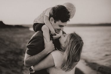 Parents embracing, with child on dad’s shoulder during Park Point family session, Duluth Minnesota