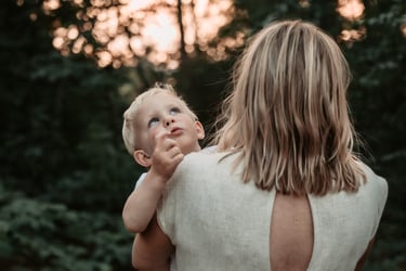 Toddler gazing at tree while mom holds them, Park Point Duluth MN
