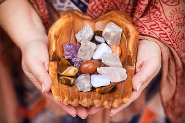 a person holding a bowl of tumbled stones
