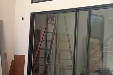 a man standing on a ladder to reach a ladder windows door cleaning post construction job