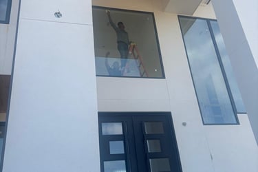 a man standing in front of a building with a window windows cleaning on post construction job
