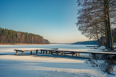 Springtime lake in Canada with partial snow and calm shoreline water.