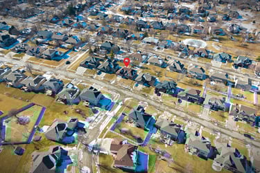 Aerial neighborhood view with property highlighted with location marker.